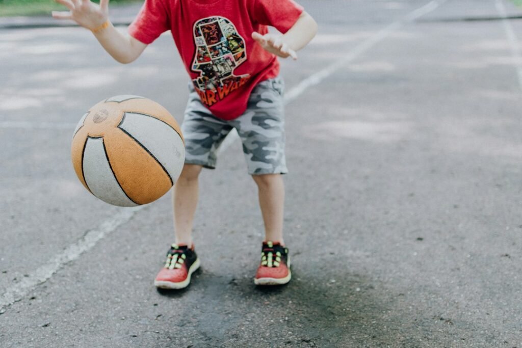 Niño practica manejo de balón durante una jornada de baloncesto formativo.