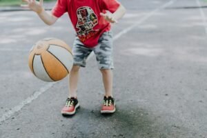 Niño practica manejo de balón durante una jornada de baloncesto formativo.