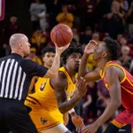 Onyeka Okongwu, de uniforme rojo de USC, se prepara para un salto entre dos en febrero de 2020