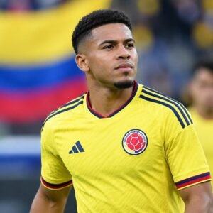 Ilustración de un futbolista con camiseta amarilla de Colombia frente a los colores de la bandera.